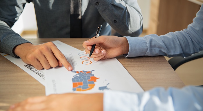 Business people studying statistic report indoors